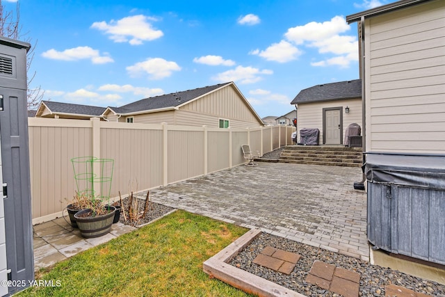 view of yard featuring a garden, a fenced backyard, and a patio area