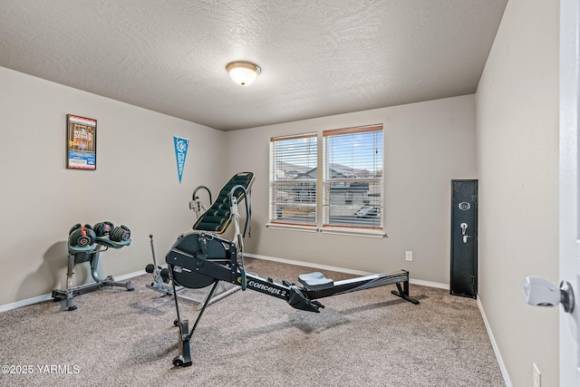 workout room featuring baseboards, carpet floors, and a textured ceiling