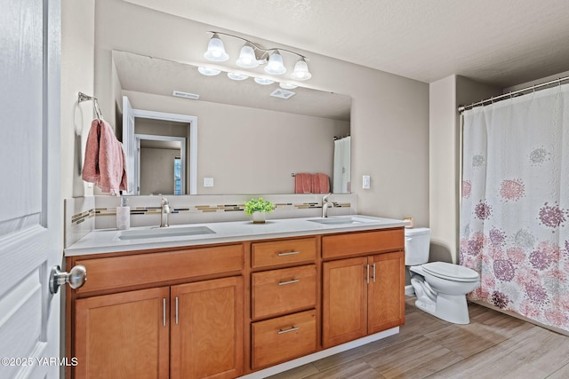 full bathroom with double vanity, visible vents, toilet, and a sink