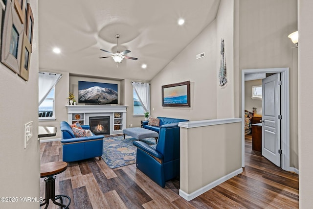 living room featuring a ceiling fan, a glass covered fireplace, wood finished floors, recessed lighting, and lofted ceiling