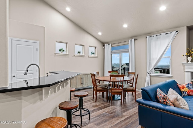 dining space featuring vaulted ceiling, recessed lighting, and wood finished floors