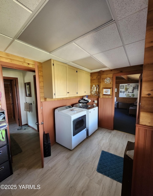 13520 Fisk Rd, Yakima, WA 98908 - laundry room featuring washer and clothes dryer, wooden walls, cabinet space, and light wood-style flooring