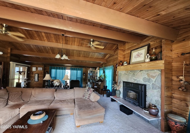 13520 Fisk Rd, Yakima, WA 98908 - carpeted living room featuring a wooden ceiling with exposed beams, wood walls, ceiling fan, and a stone fireplace