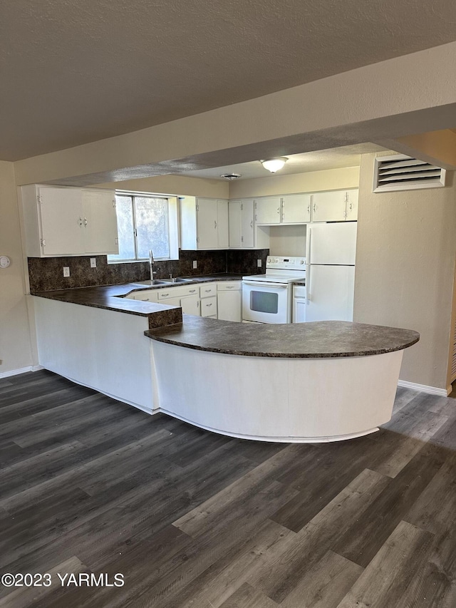 205 N 63rd Ave, Yakima, WA 98908 - kitchen with white appliances, dark countertops, a peninsula, tasteful backsplash, and white cabinetry
