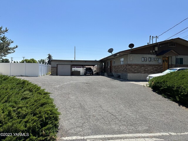 205 N 63rd Ave, Yakima, WA 98908 - view of front of house with fence, gravel driveway, a carport, and brick siding