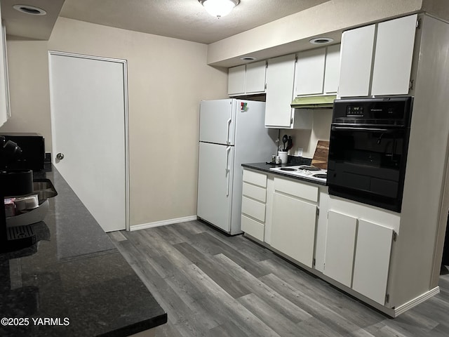 205 N 63rd Ave, Yakima, WA 98908 - kitchen featuring white appliances, light wood-style floors, under cabinet range hood, white cabinetry, and baseboards