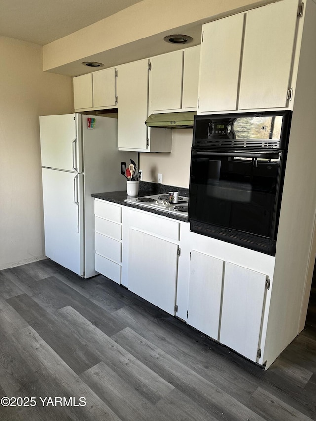 205 N 63rd Ave, Yakima, WA 98908 - kitchen featuring black oven, freestanding refrigerator, dark countertops, under cabinet range hood, and electric stovetop