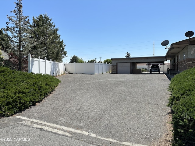 205 N 63rd Ave, Yakima, WA 98908 - view of yard with fence, a carport, and asphalt driveway