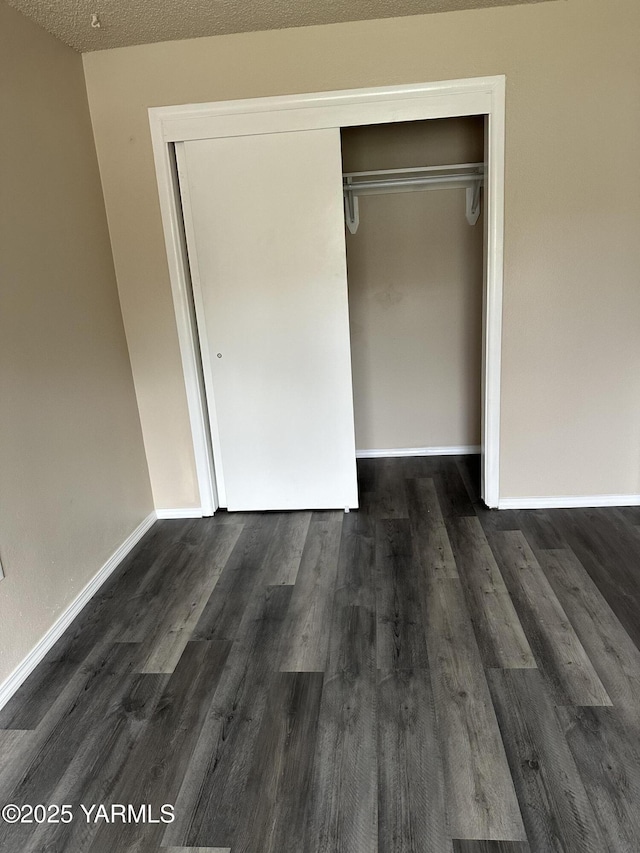205 N 63rd Ave, Yakima, WA 98908 - unfurnished bedroom with a closet, dark wood finished floors, baseboards, and a textured ceiling