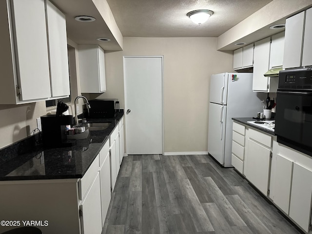 205 N 63rd Ave, Yakima, WA 98908 - kitchen featuring oven, a sink, dark countertops, white cabinetry, and a textured ceiling