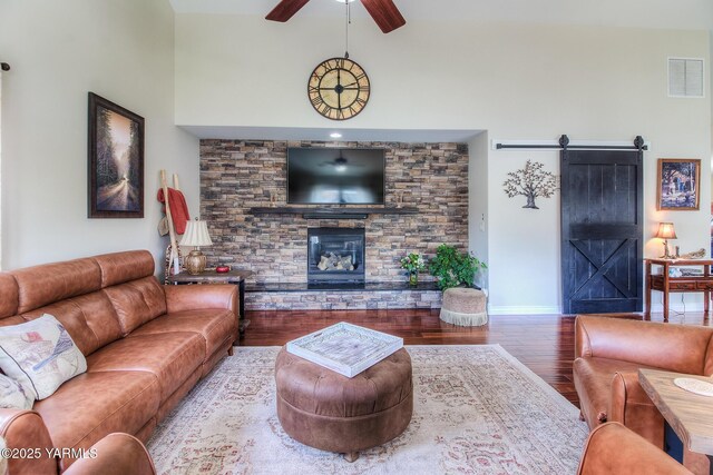 1008 S 90th Ave, Yakima, WA 98908 - living room with a barn door, wood finished floors, ceiling fan, a fireplace, and baseboards