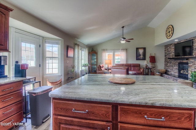 1008 S 90th Ave, Yakima, WA 98908 - kitchen with reddish brown cabinets, a ceiling fan, open floor plan, lofted ceiling, and a fireplace
