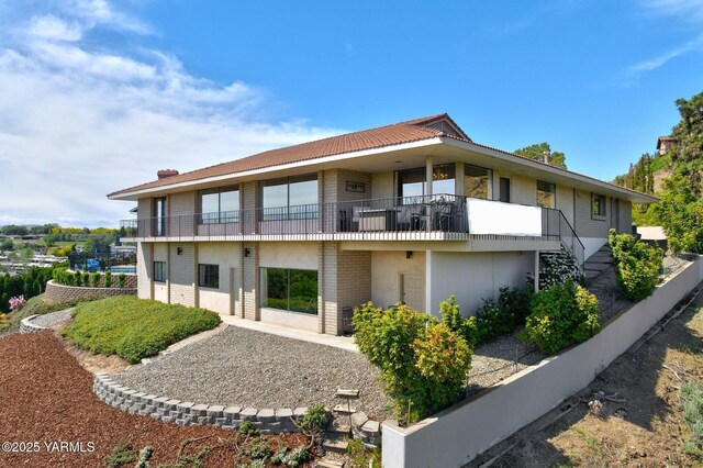 1011 N 42nd Pl, Yakima, WA 98908 - rear view of property with brick siding, a balcony, stucco siding, and stairs