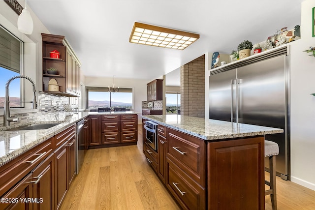1011 N 42nd Pl, Yakima, WA 98908 - kitchen featuring appliances with stainless steel finishes, open shelves, light wood-style flooring, and backsplash