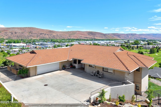 1011 N 42nd Pl, Yakima, WA 98908 - view of front of property with a tiled roof, a mountain view, an attached garage, concrete driveway, and brick siding
