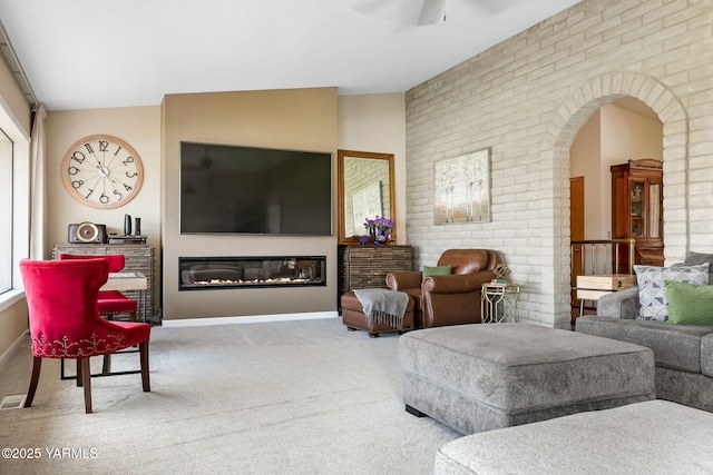 1011 N 42nd Pl, Yakima, WA 98908 - carpeted living area with a glass covered fireplace, arched walkways, and a ceiling fan