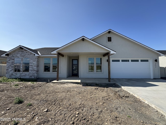 202 E Ian Ave, Ellensburg, WA 98926 - ranch-style house featuring concrete driveway, an attached garage, and stucco siding