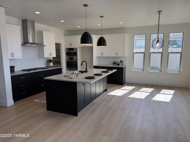 202 E Ian Ave, Ellensburg, WA 98926 - kitchen with wall chimney exhaust hood, dark cabinetry, stainless steel double oven, decorative backsplash, and recessed lighting