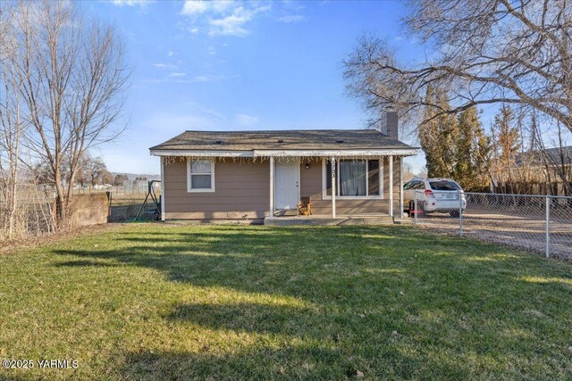 bungalow with fence, a chimney, and a front lawn