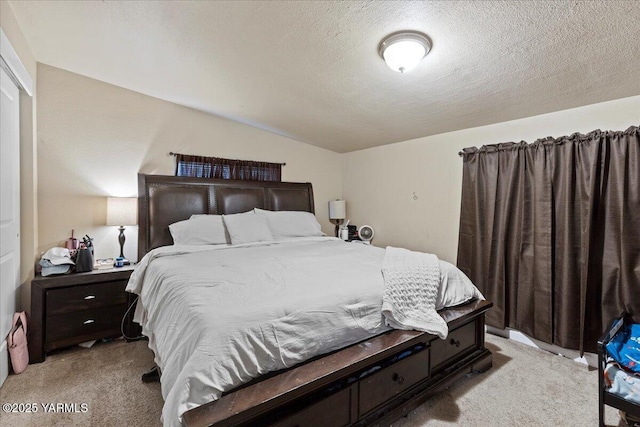 bedroom featuring lofted ceiling, light colored carpet, and a textured ceiling