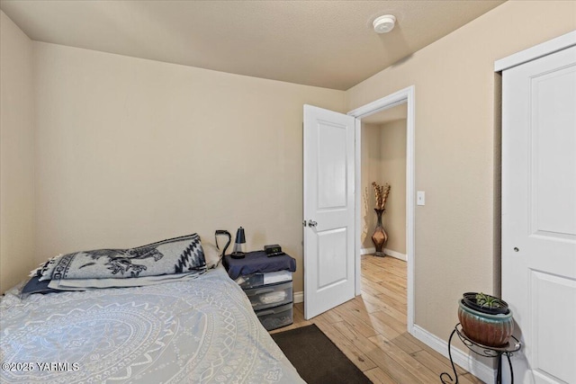 bedroom with light wood-type flooring and baseboards