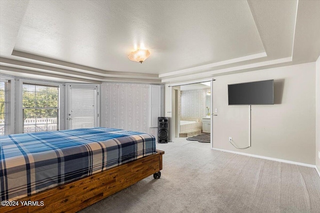 bedroom with carpet floors, a raised ceiling, a textured ceiling, and baseboards