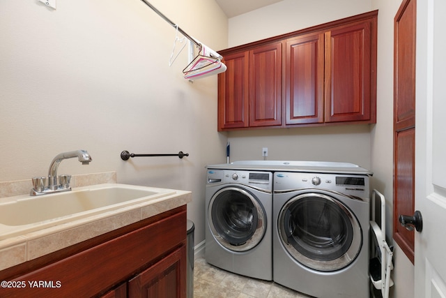 clothes washing area with washer and dryer, a sink, and cabinet space