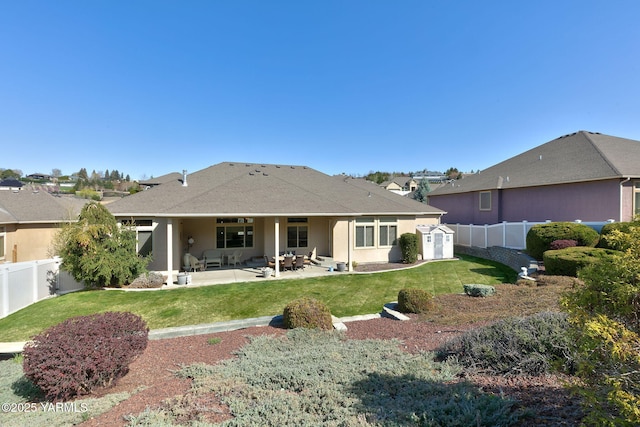 back of property with a patio area, a fenced backyard, a yard, and stucco siding