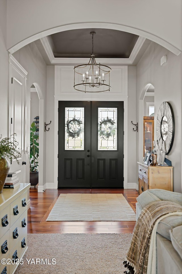 7506 Lyons Ln, Yakima, WA 98903 - entrance foyer with arched walkways, a chandelier, wood finished floors, baseboards, and a raised ceiling