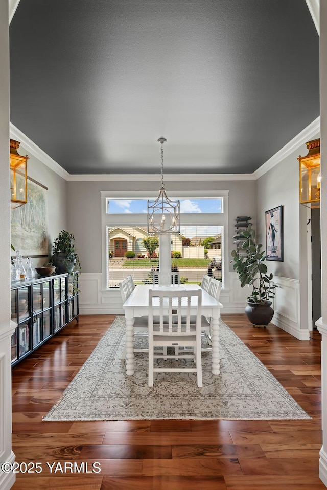 7506 Lyons Ln, Yakima, WA 98903 - dining area with a chandelier, wood finished floors, a decorative wall, crown molding, and a wainscoted wall
