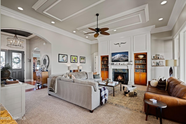 7506 Lyons Ln, Yakima, WA 98903 - living room featuring a ceiling fan, recessed lighting, a warm lit fireplace, built in shelves, and carpet flooring