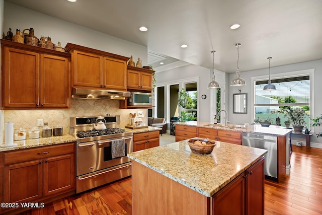 7506 Lyons Ln, Yakima, WA 98903 - kitchen with stainless steel appliances, a kitchen island with sink, under cabinet range hood, plenty of natural light, and recessed lighting