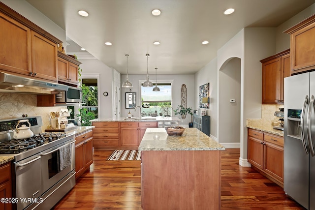 7506 Lyons Ln, Yakima, WA 98903 - kitchen with appliances with stainless steel finishes, under cabinet range hood, a center island, recessed lighting, and dark wood-style floors
