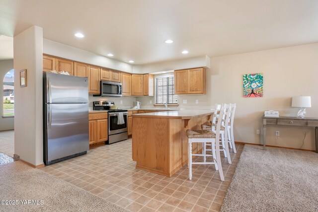 19 N 86th Ave, Yakima, WA 98908 - kitchen with a breakfast bar, stainless steel appliances, light countertops, a peninsula, and recessed lighting