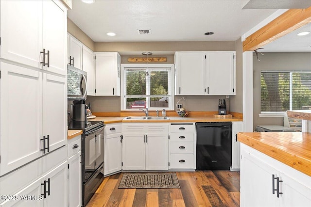 8301 Aspen Rd, Yakima, WA 98903 - kitchen featuring black appliances, wood counters, white cabinetry, wood finished floors, and recessed lighting