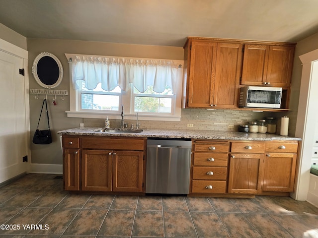 175001 W King Tull Rd, Grandview, WA 98930 - kitchen with stainless steel appliances, a sink, brown cabinets, and decorative backsplash