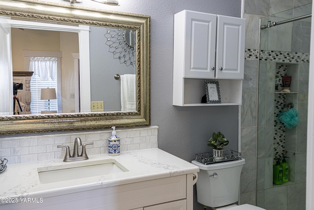 175001 W King Tull Rd, Grandview, WA 98930 - bathroom featuring vanity, toilet, a tile shower, a textured wall, and decorative backsplash
