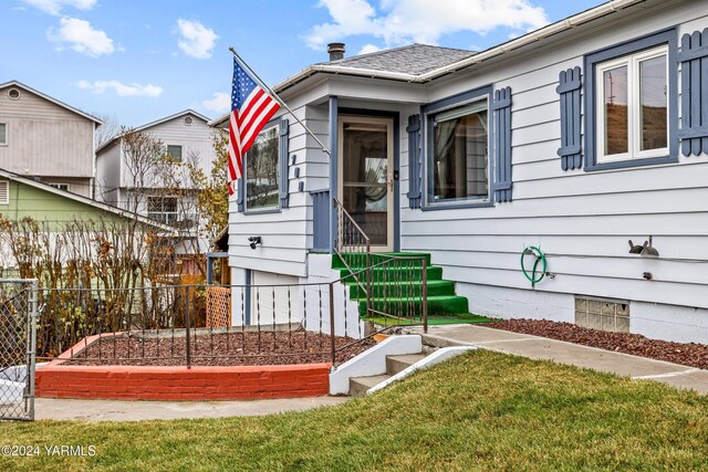 view of front of house with crawl space, fence, a vegetable garden, and a front yard