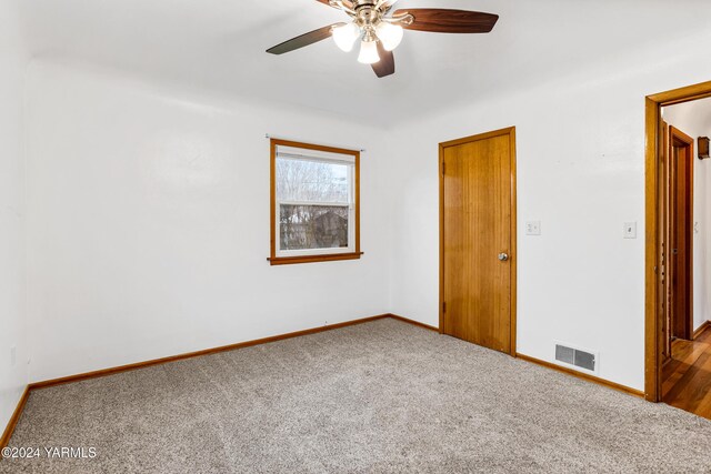 spare room with a ceiling fan, carpet, visible vents, and baseboards