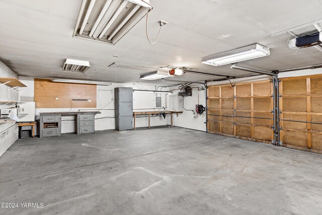 garage with a garage door opener and electric panel