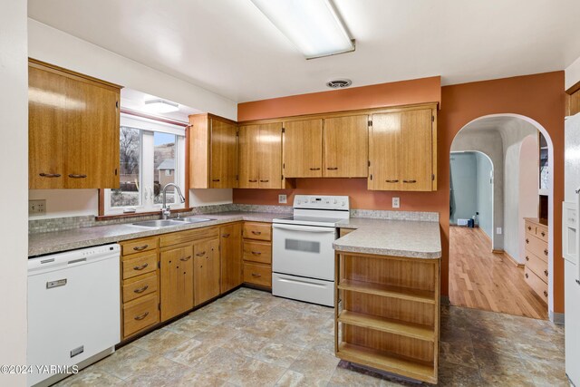 kitchen with white appliances, a sink, visible vents, brown cabinets, and open shelves