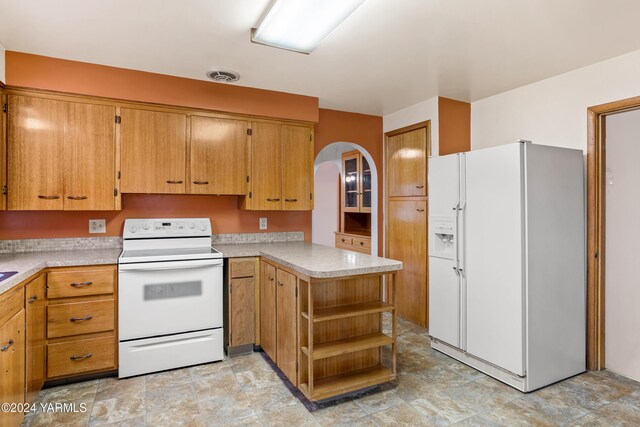 kitchen with a peninsula, white appliances, open shelves, and light countertops