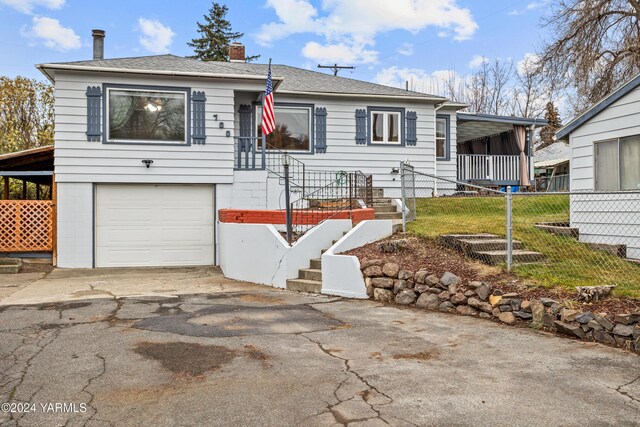 ranch-style house with driveway, an attached garage, a chimney, and a shingled roof