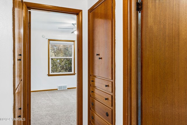 corridor featuring carpet floors, visible vents, and baseboards