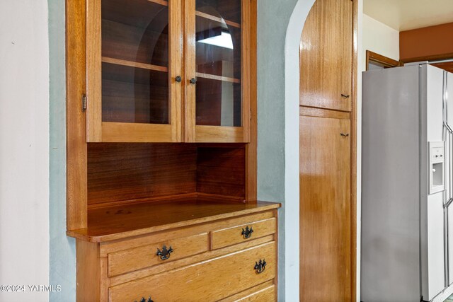 interior space with fridge with ice dispenser and arched walkways