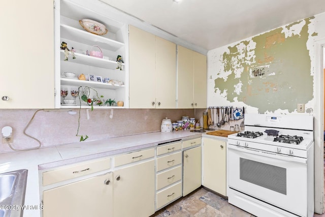 3212 W Lincoln Ave, Yakima, WA 98902 - kitchen with white range with gas cooktop, light countertops, open shelves, cream cabinets, and light stone finish floors