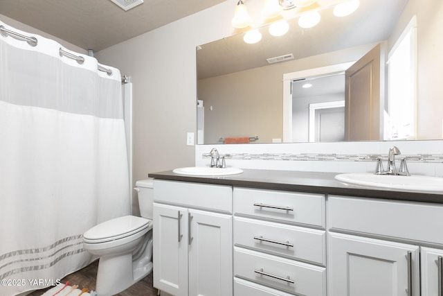 7902 W Whatcom Ave, Yakima, WA 98903 - bathroom featuring visible vents, a sink, double vanity, and toilet