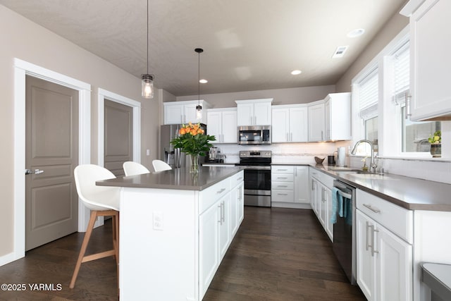 7902 W Whatcom Ave, Yakima, WA 98903 - kitchen with a kitchen island, visible vents, appliances with stainless steel finishes, a sink, and a breakfast bar