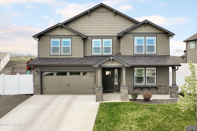 7902 W Whatcom Ave, Yakima, WA 98903 - craftsman-style house featuring fence, an attached garage, driveway, and stone siding
