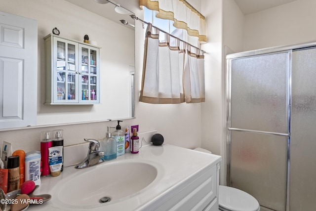 full bath featuring vanity, toilet, and a stall shower